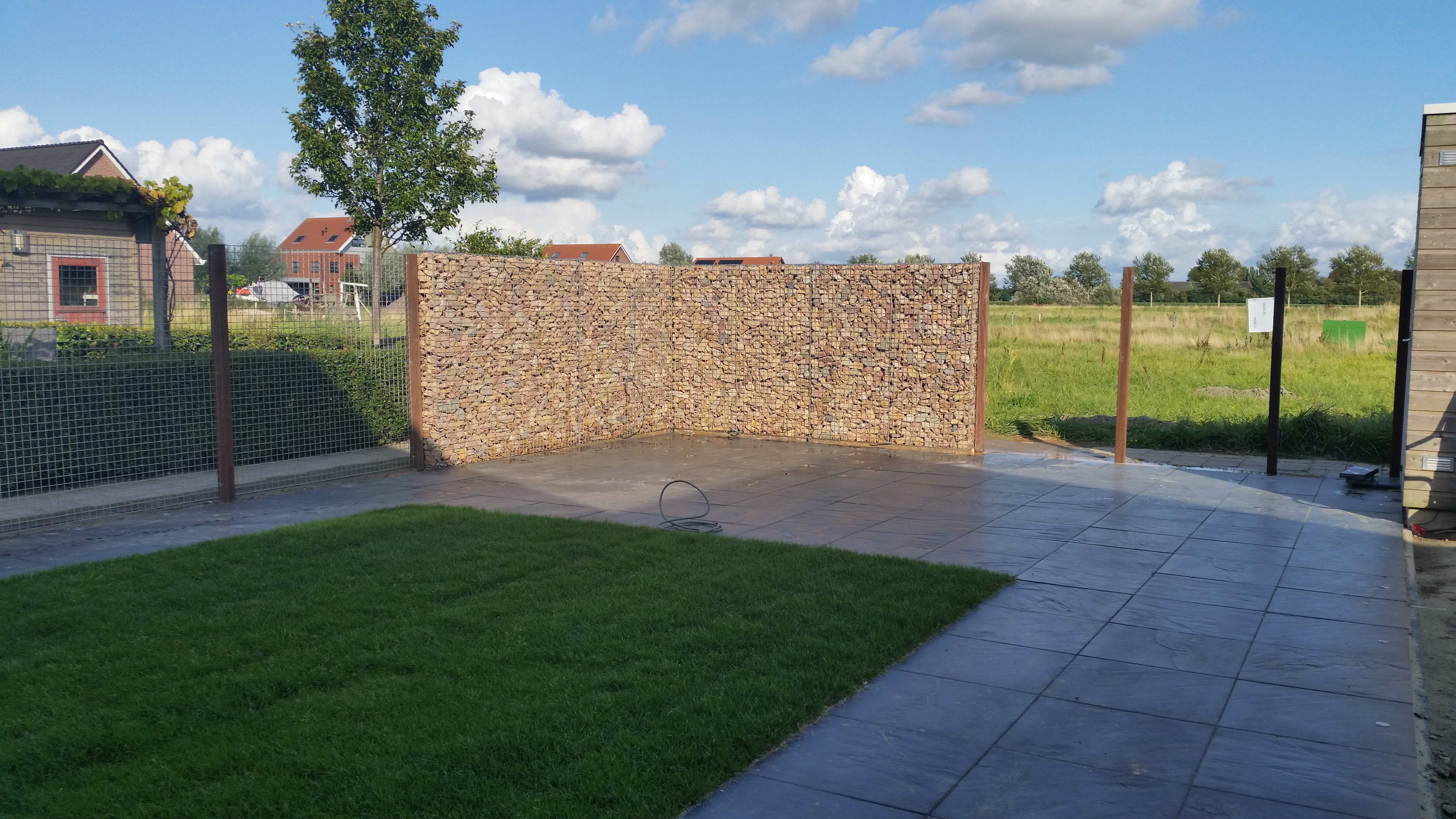 Schanskorf-schutting met Grauwacke breukstenen als geluidsbarriere in de tuin